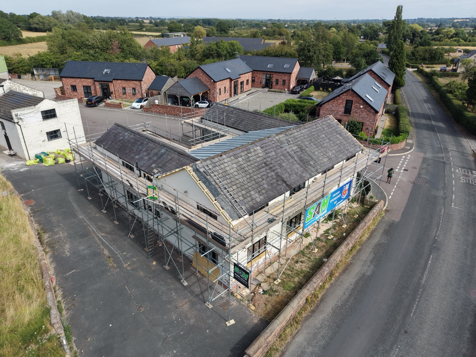 Drone view of scaffold around the front and side of Kingsley Mill for re-roofing and cladding